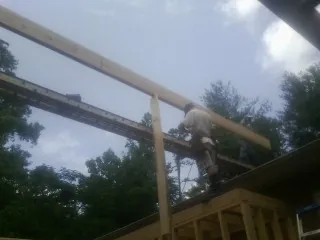 Carpenter setting a ridge beam over a new addition frame — Ice Dam Removal by Roofing Brothers in Vandergrift