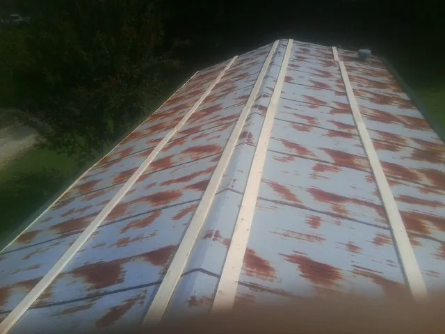 Rusted metal roof panels with new wood purlins before replacement — Storm Damage Roof Repair in Vandergrift by Roofing Brothers