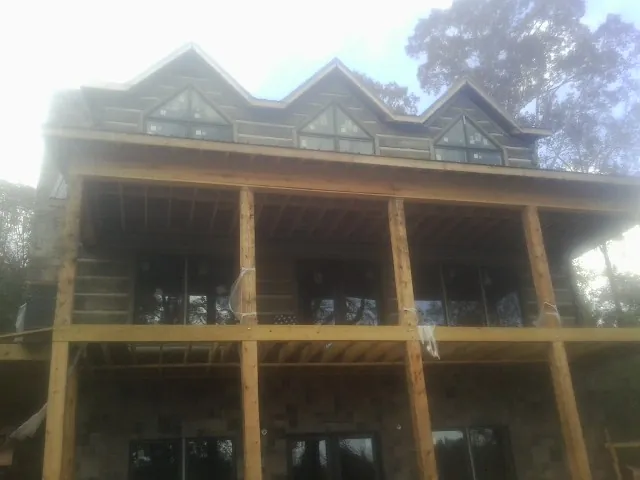 Dormers and porch framing on a large log home under construction — Roof Coating work by our crew in Vandergrift