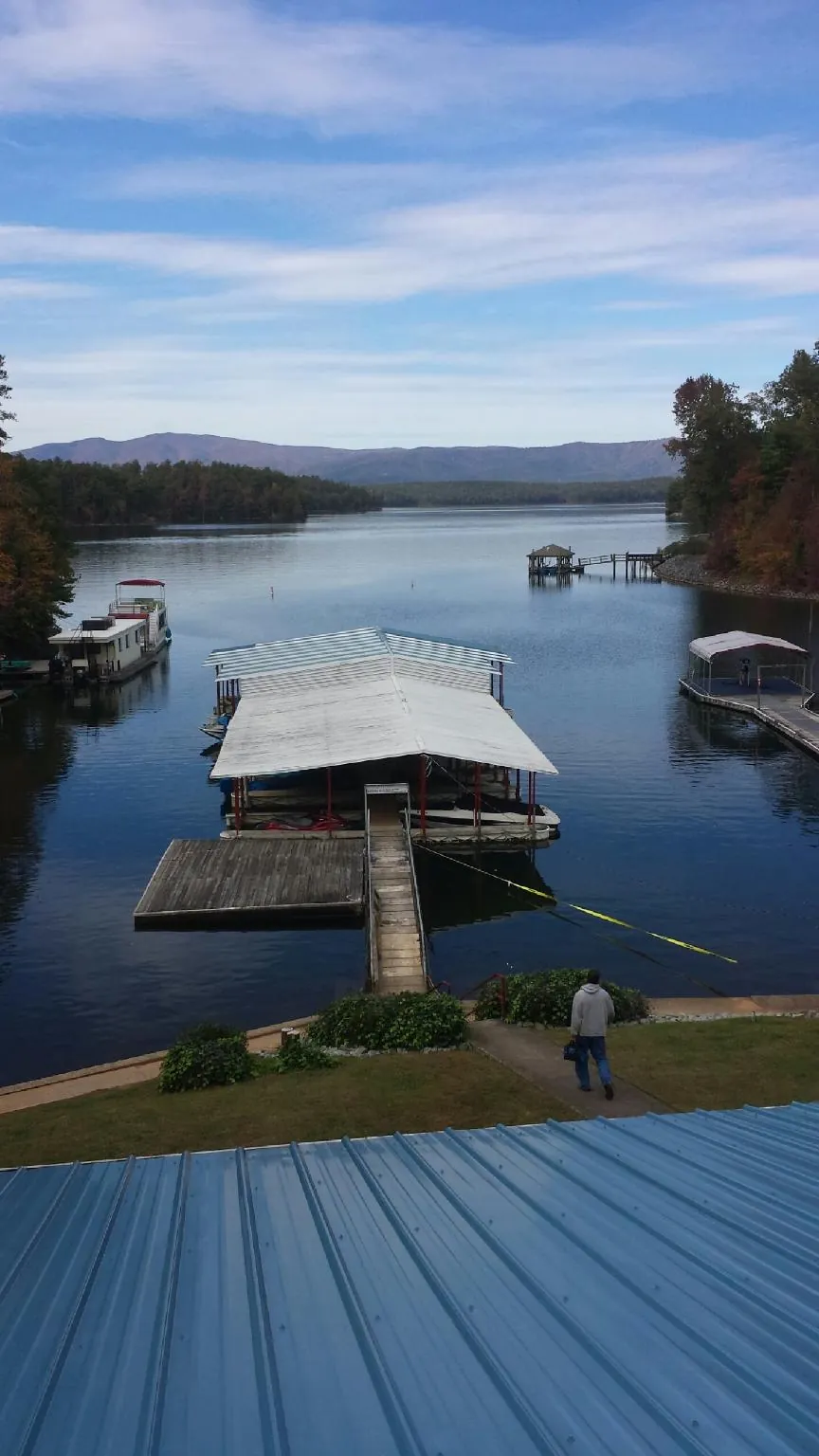 View across a lake from a newly installed blue metal roof in Vandergrift